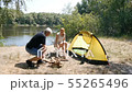 A man and a girl are sitting by the fire. The girl throws firewood in the fire. Tourism, travel 55265496
