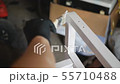 Somebody is painting with paint brush wooden part of furniture in white color. Handmade 55710488