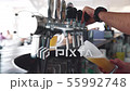 Barman hands pouring a lager beer in a glass. 55992748