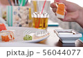 Women eating sushi with chopsticks at restaurant 56044077