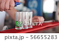 The bartender makes a shot of three alcohol cocktails. 56655283