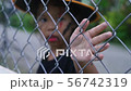 Girl's hand is touching iron fence in halloween 56742319