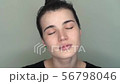 Young brunette woman with closed eyes opens her eyes. close-up 56798046