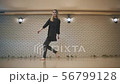 beautiful girl dances in black clothes near brick wall and jumping Wide angle 56799128