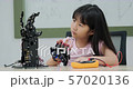 Little Girl is playing with robotic arm in a school. She is controlling it by her hand. Technology and Innovation concept. 57020136