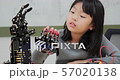 Little Girl is playing with robotic arm in a school. She is controlling it by her hand. Technology and Innovation concept. 57020138