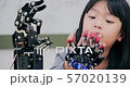 Little Girl is playing with robotic arm in a school. She is controlling it by her hand. Technology and Innovation concept. 57020139