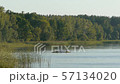 three people on a kayak swim on the lake at sunset and swim to the shore 57134020