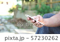 Man using a smartphone in a garden. 57230262