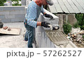 Bricklayer putting down another row of bricks in site 57262527