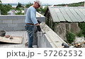 Bricklayer putting down another row of bricks in site 57262532