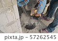 worker stirring cement mortar in a bucket with a mixer 57262545