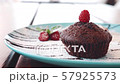 Chocolate muffin with raspberries on a blue plate 57925573