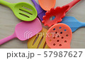 rotation of bright multi colored kitchen utensils on wooden background 57987627