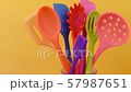 bright multi colored kitchen utensils on yellow background 57987651