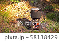 Pot boiling on wood burning twig stove outdoors 58138429