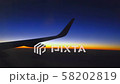 Wing of plane on sunset sky and clouds 58202819