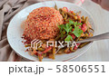 Adding Aleppo pepper into Turkish dinner with bulgur pilaf, green beans, onion and tomato 58506551