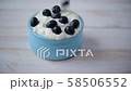 Slow motion clip of fresh blueberries dropping into a jar with quark dessert 58506552
