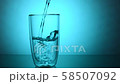 Pouring fresh drink water into a glass on blue background 58507092