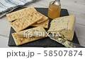 Woman makes sandwich with blue cheese and jam on a crisp bread 58507874