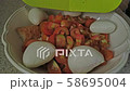 Adding small mozzarella balls in a white bowl with chopped tomatoes and bread. Preparing italian salad Panzanella with bread, tomato and mozzarella. 58695004