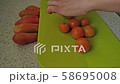 Female hands cutting tomatoes on green chopping board. Preparing italian salad Panzanella with dry bread and tomato. 58695008