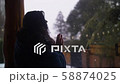 Woman Near window while snowing 58874025