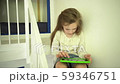 Serious cute little girl sitting on bed stairs using tablet computer. Handheld 59346751