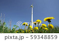 Clean wind energy generator turbine and yellow dandelion flowers move in wind 59348859
