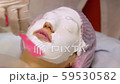 Young woman in beauty salon does alginate mask. Application of moisturizing, softening, regenerating mask before the rejuvenating, toning procedure darsonval on the face. Medical beauty equipment. 59530582