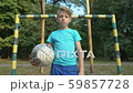 Serious boy with football looking into camera at 59857728