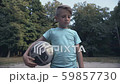 Lonely upset boy holding football at pitch, lack 59857730