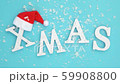 Text Xmas from volume white letters in red Santa hat and falling snow on blue background. Concept 59908800
