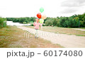 little girl with balloons in the park 60174080