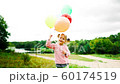 little girl with balloons in the park 60174519