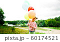 little girl with balloons in the park 60174521