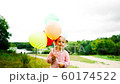 little girl with balloons in the park 60174522