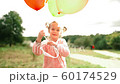 little girl with balloons in the park 60174529