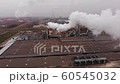 Wood processing plant pollutes the air with smoke coming from the pipe. Aerial view. 60545032