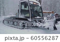 Ski resort entertainments. Snow Grooming Machine at Ski Resort. Snow grooming machine drives away leaving path of smooth corduroy snow for skiers Krasnaya Polyana 60556287