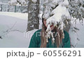 Ski resort entertainments. Happy young woman playing with snow SLOW MOTION 60556291