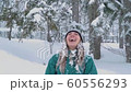 Ski resort entertainments. Happy young woman playing with snow 60556293