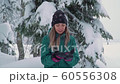 Ski resort entertainments. Happy young woman playing with snow SLOW MOTION 60556308