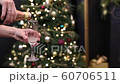 Celebration festive champagne pouring into a glass with gas and bubbles on the background of a Christmas tree in bokeh 60706511