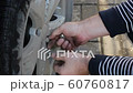 The man driver tighten the bolts to change the wheel of a car 60760817