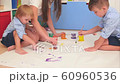 Young mother showing her little sons how to paint the sun 60960536