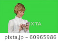 Young attractive woman works on smartphone and smiles on a Green Screen, Chroma Key 60965986