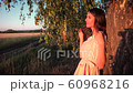 Young woman on wheat field at sunset 60968216