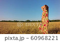 Young woman on wheat field at sunset 60968221